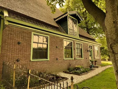 an old brick house with a window on it at De Noorderzon in Benningbroek