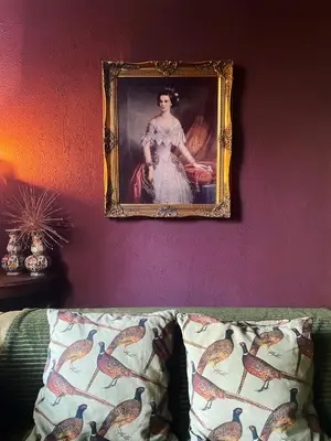 a painting of a woman on a wall next to a couch at De Noorderzon in Benningbroek