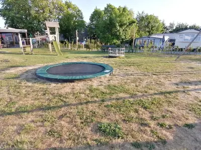 a playground with a trampoline in the grass at Villa-43 in Sint Maarten