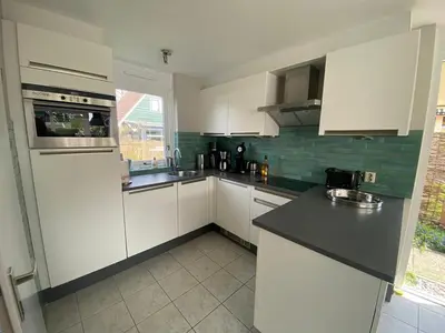 a kitchen with white cabinets and a black counter top at Villa-43 in Sint Maarten
