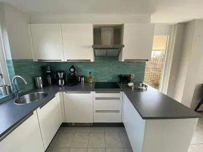 a kitchen with white cabinets and a black counter top at Villa-43 in Sint Maarten