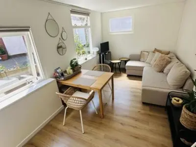a living room with a table and a couch at Holiday Home Tiny House QuDi by Interhome in Noordwijk