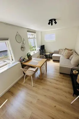 a living room with a table and a couch at Holiday Home Tiny House QuDi by Interhome in Noordwijk