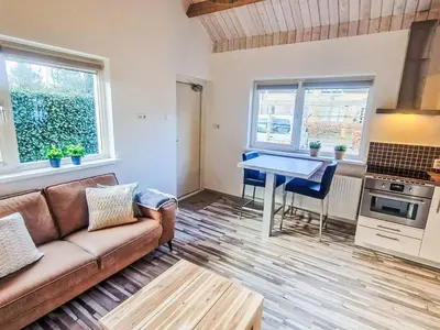 a living room with a couch and a table at Holiday Home De Bosuil by Interhome in Noordwijk aan Zee