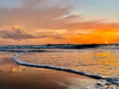 a sunset on the beach with the ocean at Holiday Home De Bosuil by Interhome in Noordwijk aan Zee