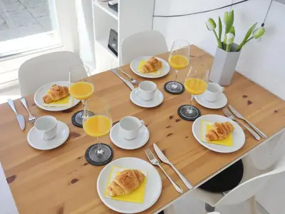 a table with plates of food and glasses of orange juice at Holiday Home De Bosuil by Interhome in Noordwijk aan Zee