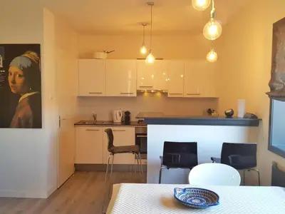 a kitchen with white cabinets and a table and chairs at Apartment Bella by Interhome in Noordwijk aan Zee