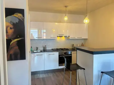 a kitchen with a painting of a woman at Apartment Bella by Interhome in Noordwijk aan Zee