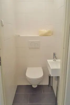 a white bathroom with a toilet and a sink at Apartment Bella by Interhome in Noordwijk aan Zee