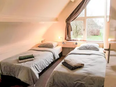two beds in a room with a window at Holiday Home Sunset by Interhome in Noordwijkerhout