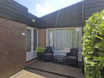 a patio with two chairs and a table at Holiday Home Zeelust by Interhome in Noordwijkerhout