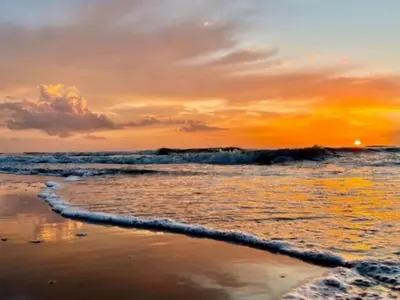 a sunset on the beach with the ocean at Holiday Home Zeelust by Interhome in Noordwijkerhout