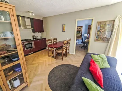 a living room and kitchen with a couch and a table at Holiday Home Zeelust by Interhome in Noordwijkerhout