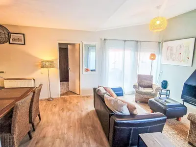 a living room with a couch and a table at Holiday Home Zeemeeuw by Interhome in Noordwijkerhout