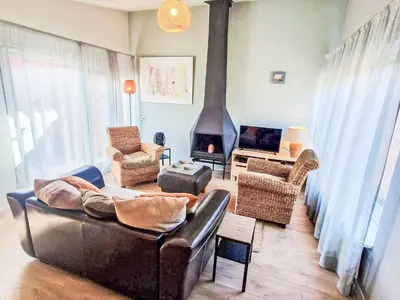 a living room with a couch and a fireplace at Holiday Home Zeemeeuw by Interhome in Noordwijkerhout