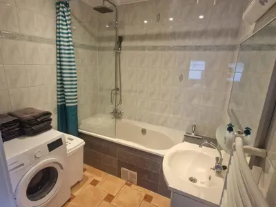 a bathroom with a washing machine and a sink at Holiday Home Zeemeeuw by Interhome in Noordwijkerhout