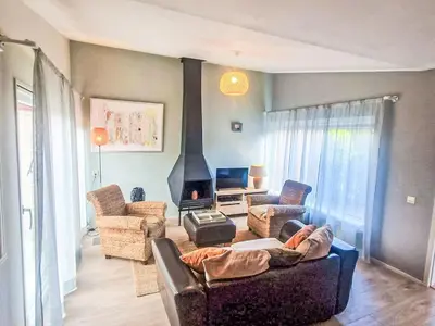 a person laying on a couch in a living room at Holiday Home Zeemeeuw by Interhome in Noordwijkerhout