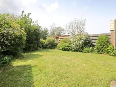 a yard with bushes and trees and a building at Holiday Home Hollandsche Tulp by Interhome in Noordwijkerhout