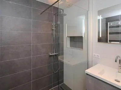 a shower with a glass door in a bathroom at Holiday Home Hollandsche Tulp by Interhome in Noordwijkerhout