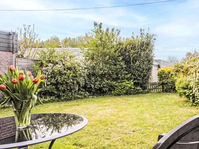 a vase of tulips on a table in a yard at Holiday Home Hollandsche Tulp by Interhome in Noordwijkerhout