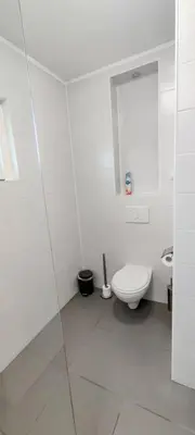 a white bathroom with a toilet and a mirror at Villa near Amsterdam in Almere