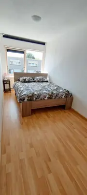 a bedroom with a bed and a large window at Villa near Amsterdam in Almere
