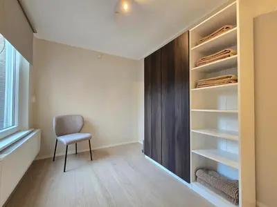 a walk in closet with a chair in a room at 't Vissershop in Egmond aan Zee