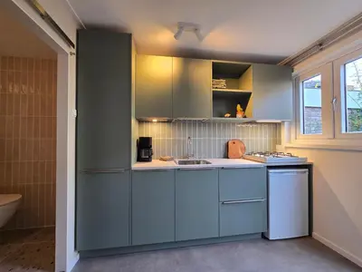 a kitchen with blue cabinets and a sink at 't Vissershop in Egmond aan Zee