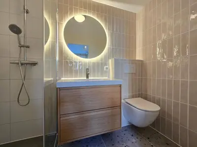 a bathroom with a sink and a toilet and a mirror at 't Vissershop in Egmond aan Zee