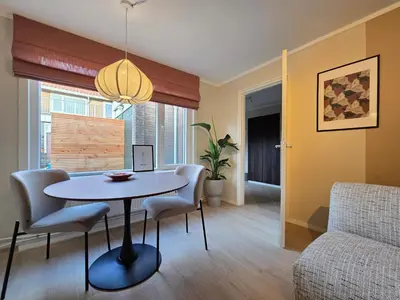a living room with a table and chairs at 't Vissershop in Egmond aan Zee