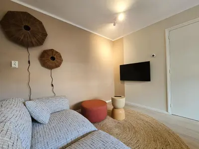a bedroom with a bed and a flat screen tv at 't Vissershop in Egmond aan Zee