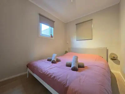 a bedroom with a pink bed with two stuffed animals on it at 't Vissershop in Egmond aan Zee