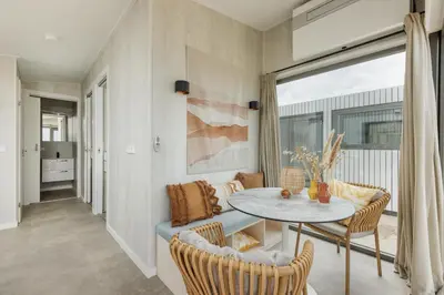 a living room with a table and a couch at Cabana's direct op het strand in Zandvoort