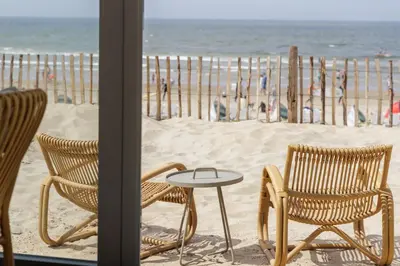 two chairs and a table in front of the beach at Cabana's direct op het strand in Zandvoort