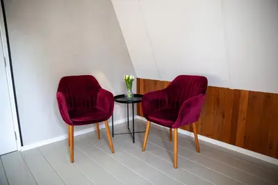 two purple chairs and a table with a vase of flowers at De Tuinfluiter 7 in Noordwijk aan Zee