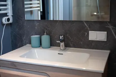 a bathroom sink with two blue vases on it at De Tuinfluiter 7 in Noordwijk aan Zee