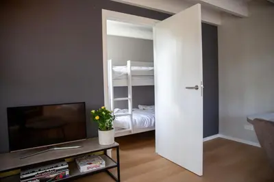 a living room with a sliding door leading to a bedroom at De Tuinfluiter 7 in Noordwijk aan Zee