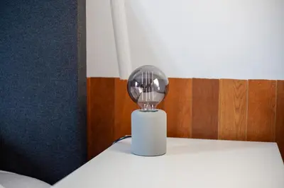 a silver lamp sitting on top of a bed at De Tuinfluiter 7 in Noordwijk aan Zee