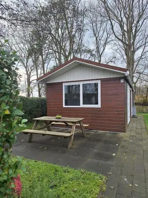 a picnic table in front of a tiny house at Huisje aan het einde - 273 in Warmenhuizen