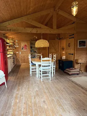 a dining room with a table and chairs in a cabin at Houten familiehuisje Noordwijk met grote tuin in Noordwijk aan Zee