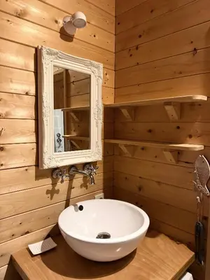 a bathroom with a white sink and a mirror at Houten familiehuisje Noordwijk met grote tuin in Noordwijk aan Zee