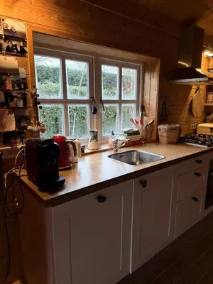 a kitchen with a sink and a counter top at Houten familiehuisje Noordwijk met grote tuin in Noordwijk aan Zee