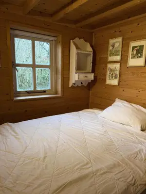 a bedroom with a large white bed in a cabin at Houten familiehuisje Noordwijk met grote tuin in Noordwijk aan Zee
