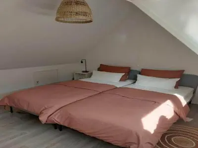 a bedroom with a large bed with red sheets at Dirkshorn Holiday Home for 4 in Dirkshorn