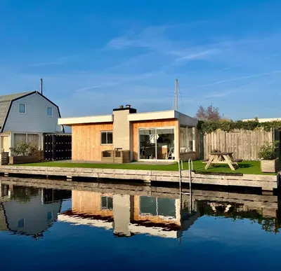 a house next to a body of water at Chalet Kievietsbuurt Roeleveld Estate in Breukelen