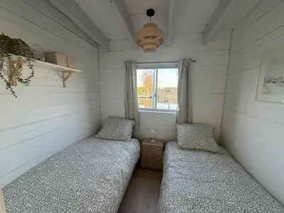 two beds in a small room with a window at Chalet Kievietsbuurt Roeleveld Estate in Breukelen