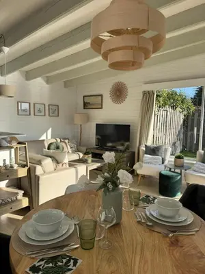 a living room with a table and a chandelier at Chalet Kievietsbuurt Roeleveld Estate in Breukelen