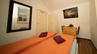 a bedroom with an orange bed and a mirror at Studio De Gravin in Gouda