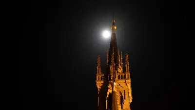 a clock tower with the moon on top of it at Studio De Gravin in Gouda