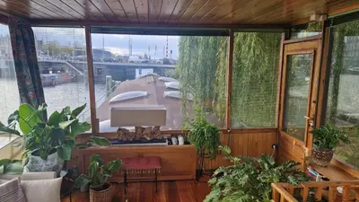 a house with a boat in a room with plants at Cornelia Below Deck in Amsterdam
